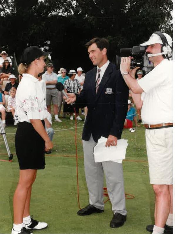 Peter Gee interviewing Webb on golf course with cameraman filming.