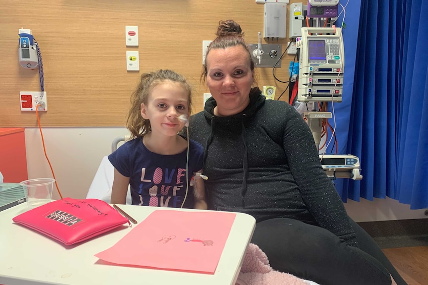 Hayley Minson-Rivers sitting in a hospital bed next to her mother Cathrine Minson