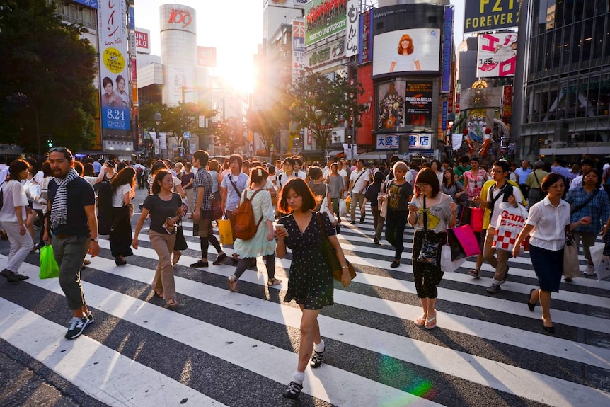 Crowds cross the road in Shibuya, a district of Tokyo.
