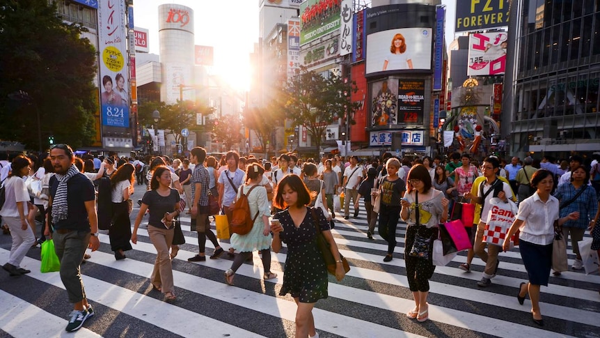 Crowds cross the road in Shibuya, a district of Tokyo.