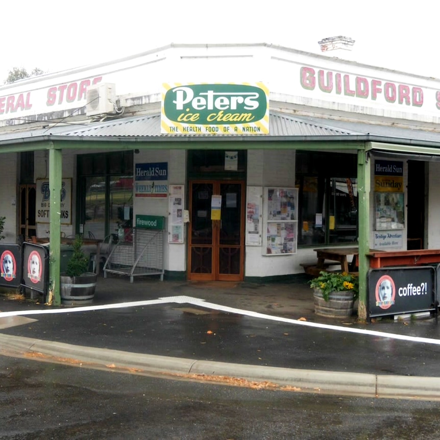 An old white building stands empty at a corner