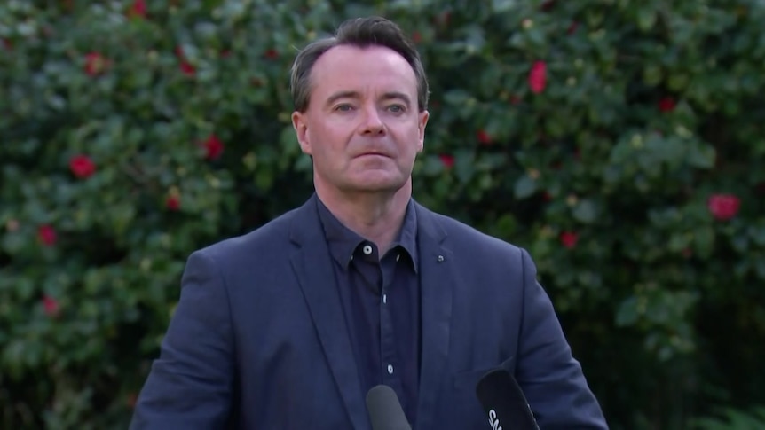 Michael O'Brien stands in front of a microphone at a press conference.