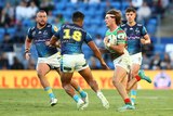 A South Sydney NRL player runs through the defence with the ball as Gold Coast players try to stop him.