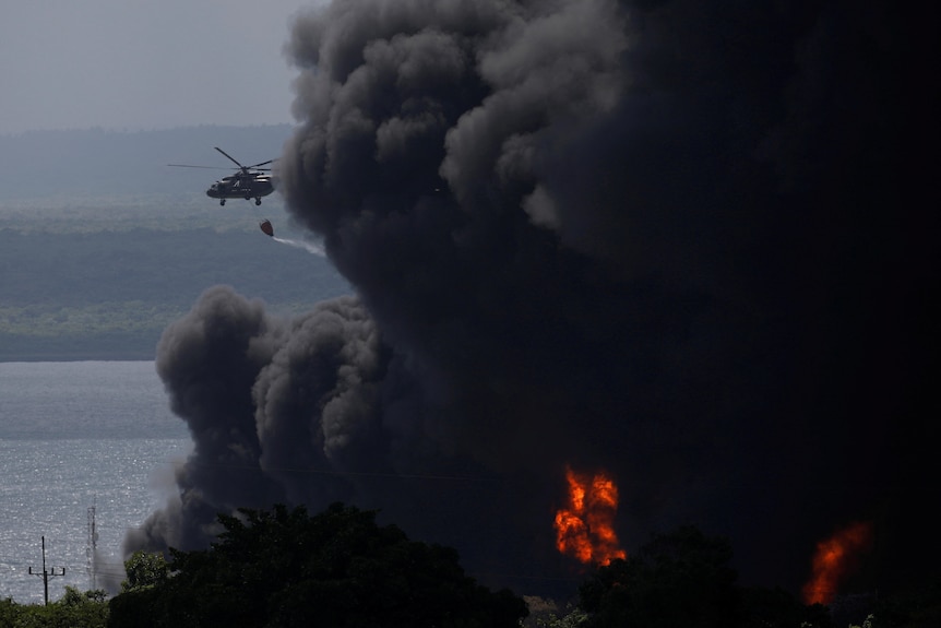 A helicopter drops water on a massive blaze. 