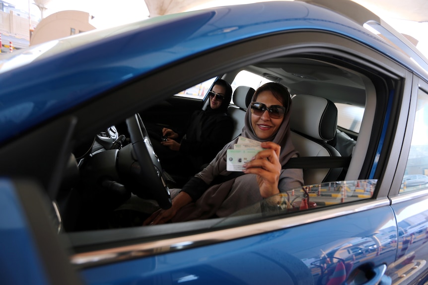 A Saudi woman smiles with her national ID at the Bahrain immigration checkpoint.