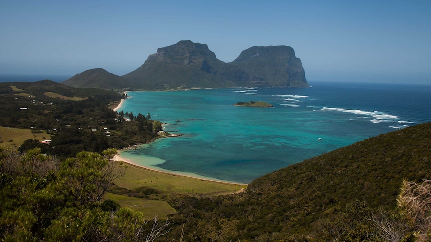 A shot of an island bay, hemmed by craggy rock formations.