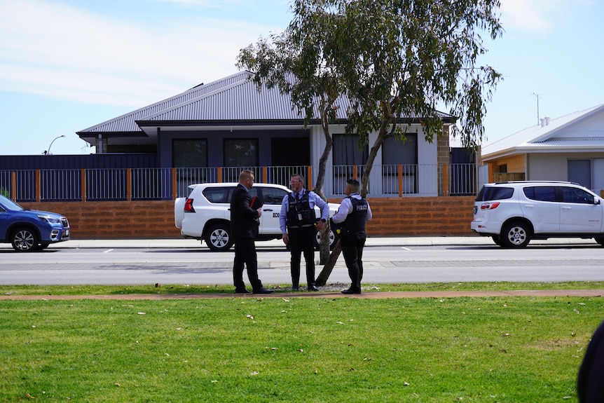 A wide shot of three police officers standing by a road in Ellenbrook with a house in the background