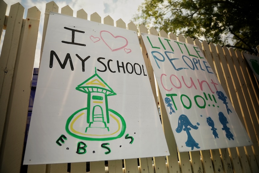 Signs outside East Brisbane State School read 'I love my school' and 'little people count too'