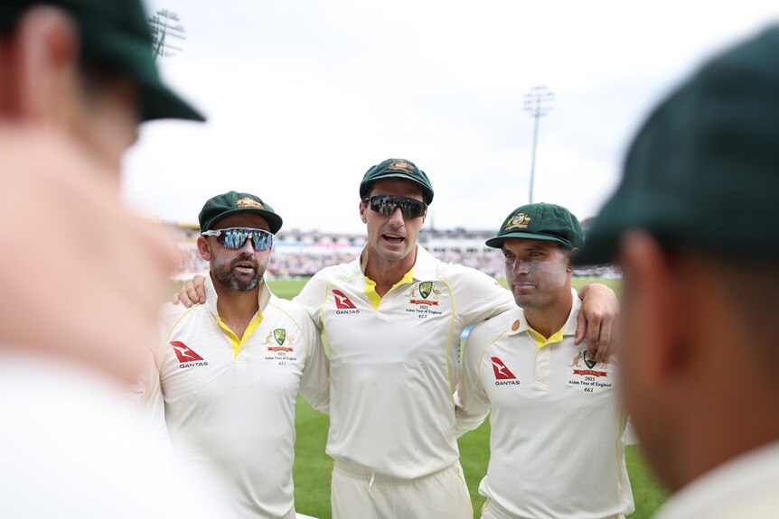 Pat Cummins speaks while standing arm in arm with Nathan Lyon and Alex Carey