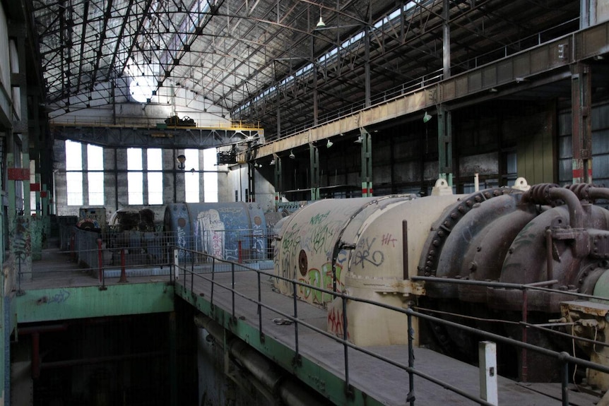 Inside of an old run-down power station with graffiti.