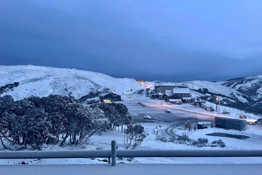 a large mountain covered in thick snow below a dark and cloudy sky at Mount Hotham