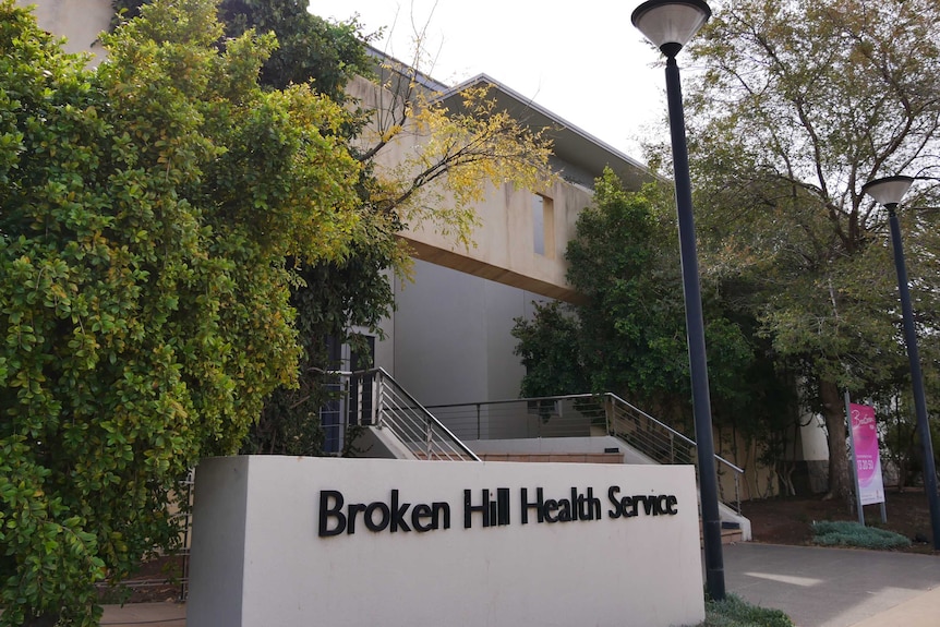 A photograph of the entrance to a hospital with a sign reading "Broken Hill Health Service".