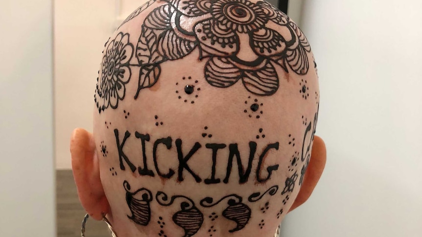 Henna crown, on a woman's bald head, including the words 'kicking cancer'.