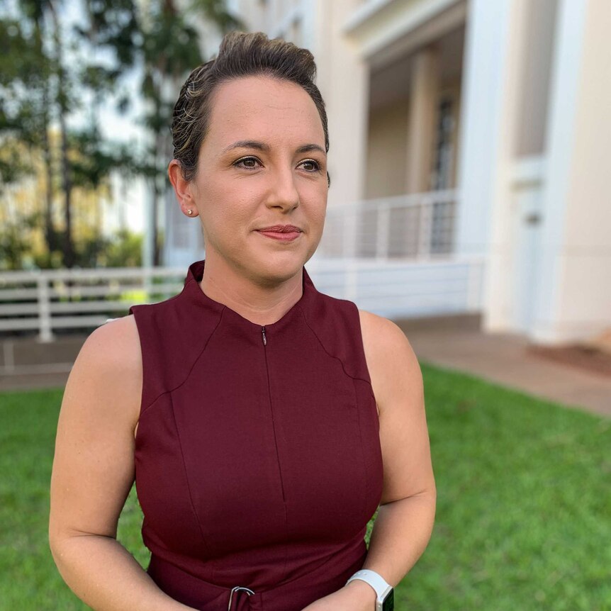 A portrait of Lia Finocchiaro, staring slightly off-camera and standing outside the NT Parliament building.