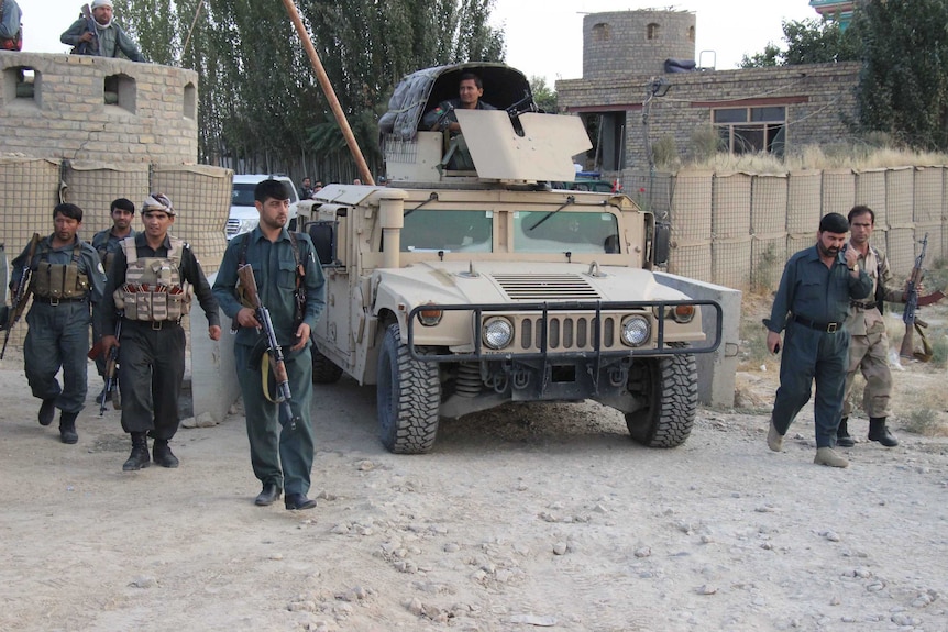 Afghan security personnel keep watch as heavy fighting erupted near Kunduz airport
