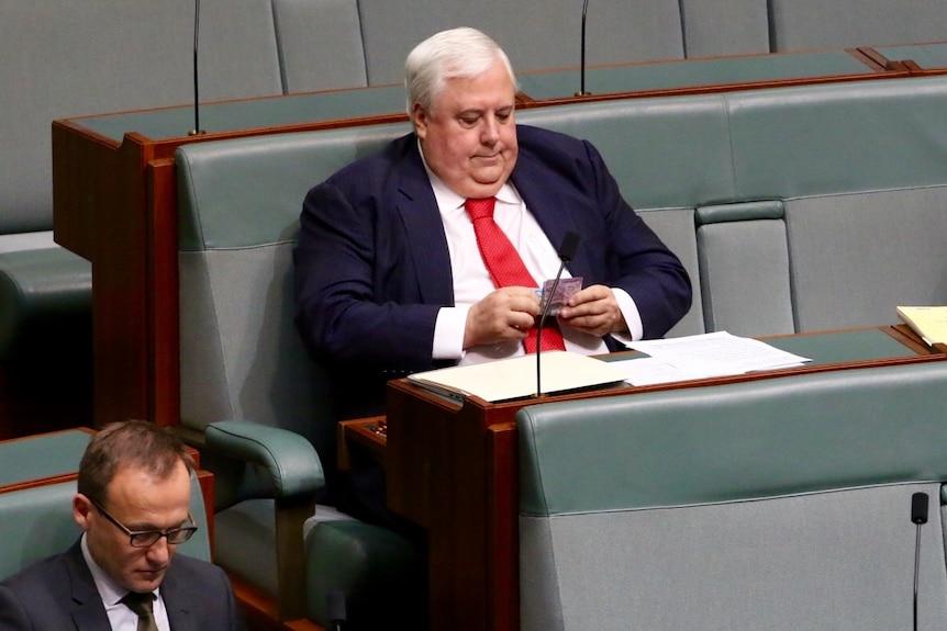 Clive Palmer setting in Federal Parliament wearing a suit.