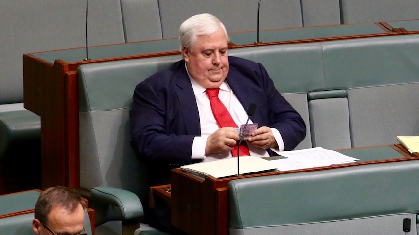 Clive Palmer setting in Federal Parliament wearing a suit.