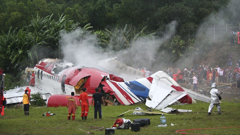 Wreckage: Rescue workers stand by the remains of the airliner
