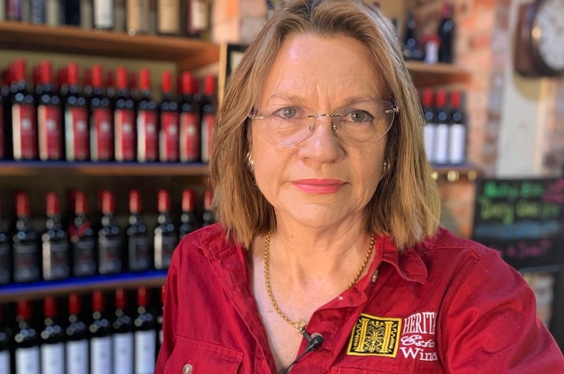 Woman in front of shelves of red wines