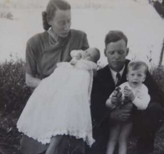 black and white family photo of baby in christening dress