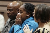 Katrina Johnson is emotional in court. A woman sitting beside her comforts her.