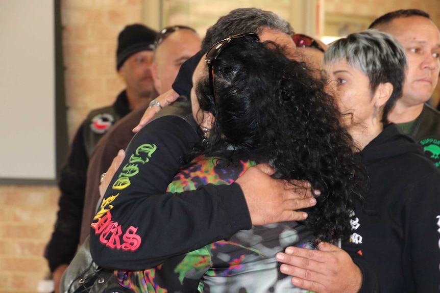 Two mourners at the vigil embrace.