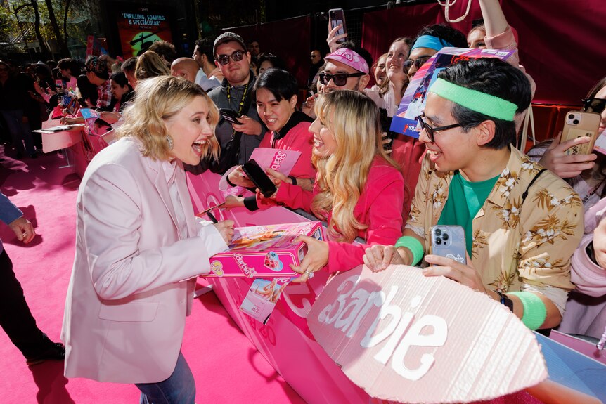 Greta Gerwig signing a Barbie box for a fan