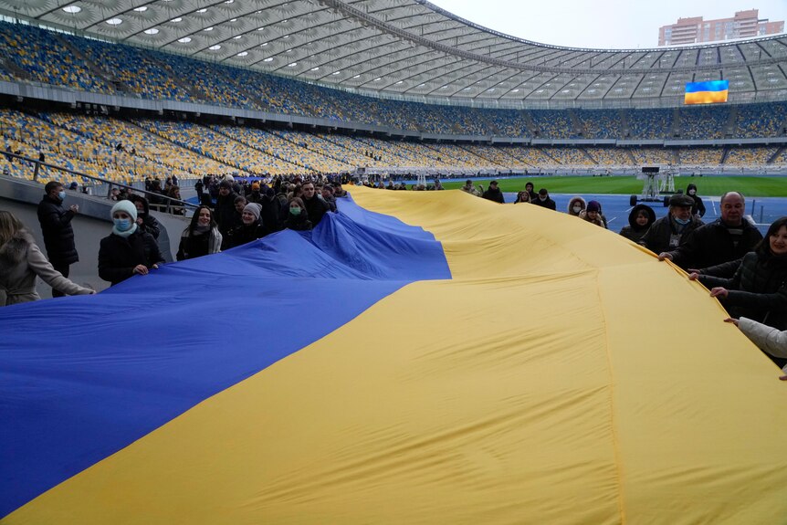 Na stadion wnoszona jest wysoka flaga Ukrainy