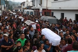 A crowd of people carry coffins of victims who died during the eruption of the Fuego volcano.