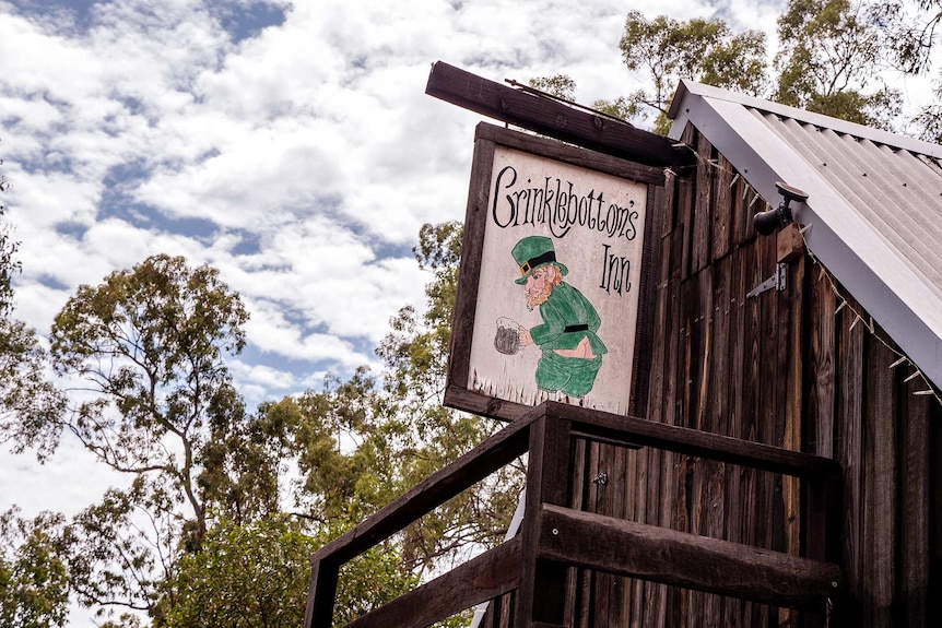 A sign on an old style timber building that says 'Crinklebottom's Inn.'