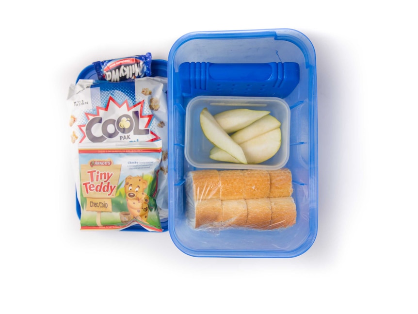 Chopped up french stick bread with butter, sliced pear, tiny teddy biscuits, popcorn and a Milkyway in a lunch box.