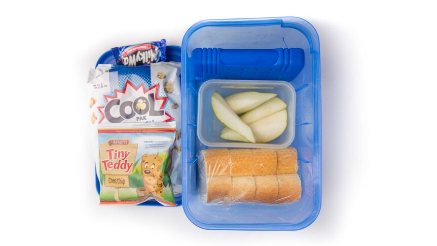 Chopped up french stick bread with butter, sliced pear, tiny teddy biscuits, popcorn and a Milkyway in a lunch box.