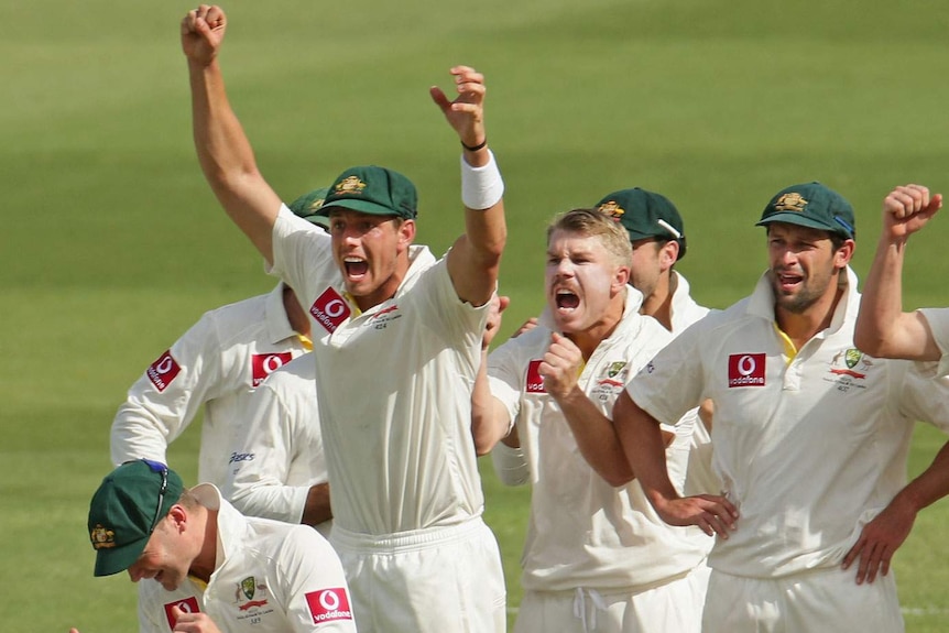 Unlikely wicket... David Warner (centre) and the Australian team celebrate as the third umpire confirms Amla's dismissal.