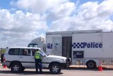 Vehicles are stopped outside Wedge Island as police question drivers over man's death