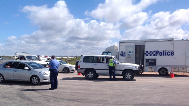 Vehicles are stopped outside Wedge Island as police question drivers over man's stabbing death during brawl