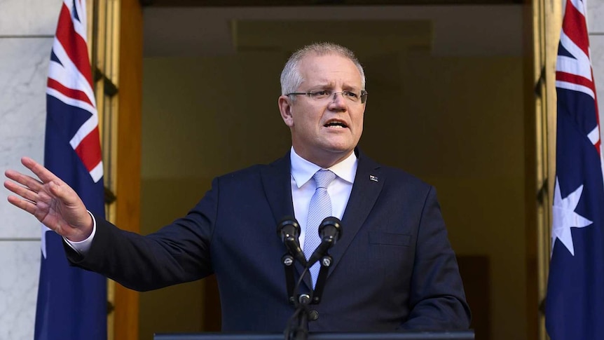 Scott Morrison speaks from a lectern with his hand outstretched