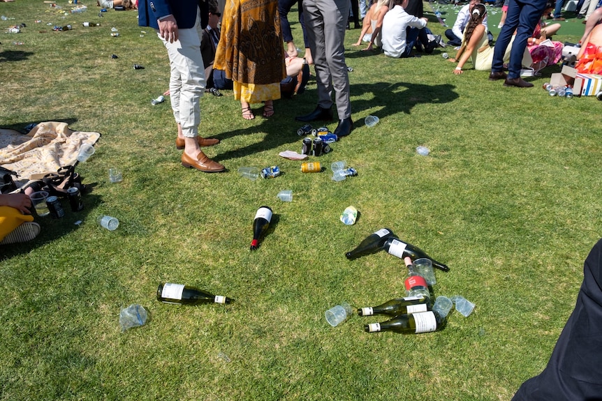 Empty bottles and cups and cubbish lay scattered on the grass at the Flemington Racecourse.