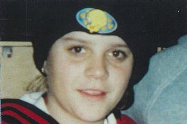 A young woman in a black beanie in a family snapshot.