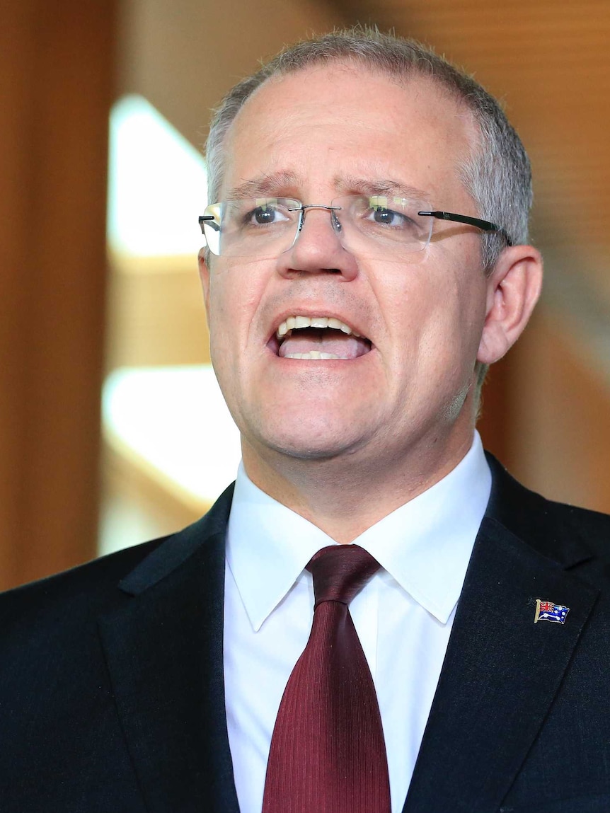 Scott Morrison gestures with his left hand and two fingers during a press conference