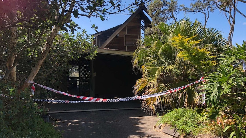 Fire damaged house at Peregian Beach with police tape in front.