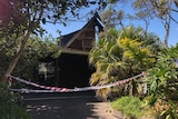 Bushfire-damaged house of Pam Murphy at Peregian Beach with police tape in front.
