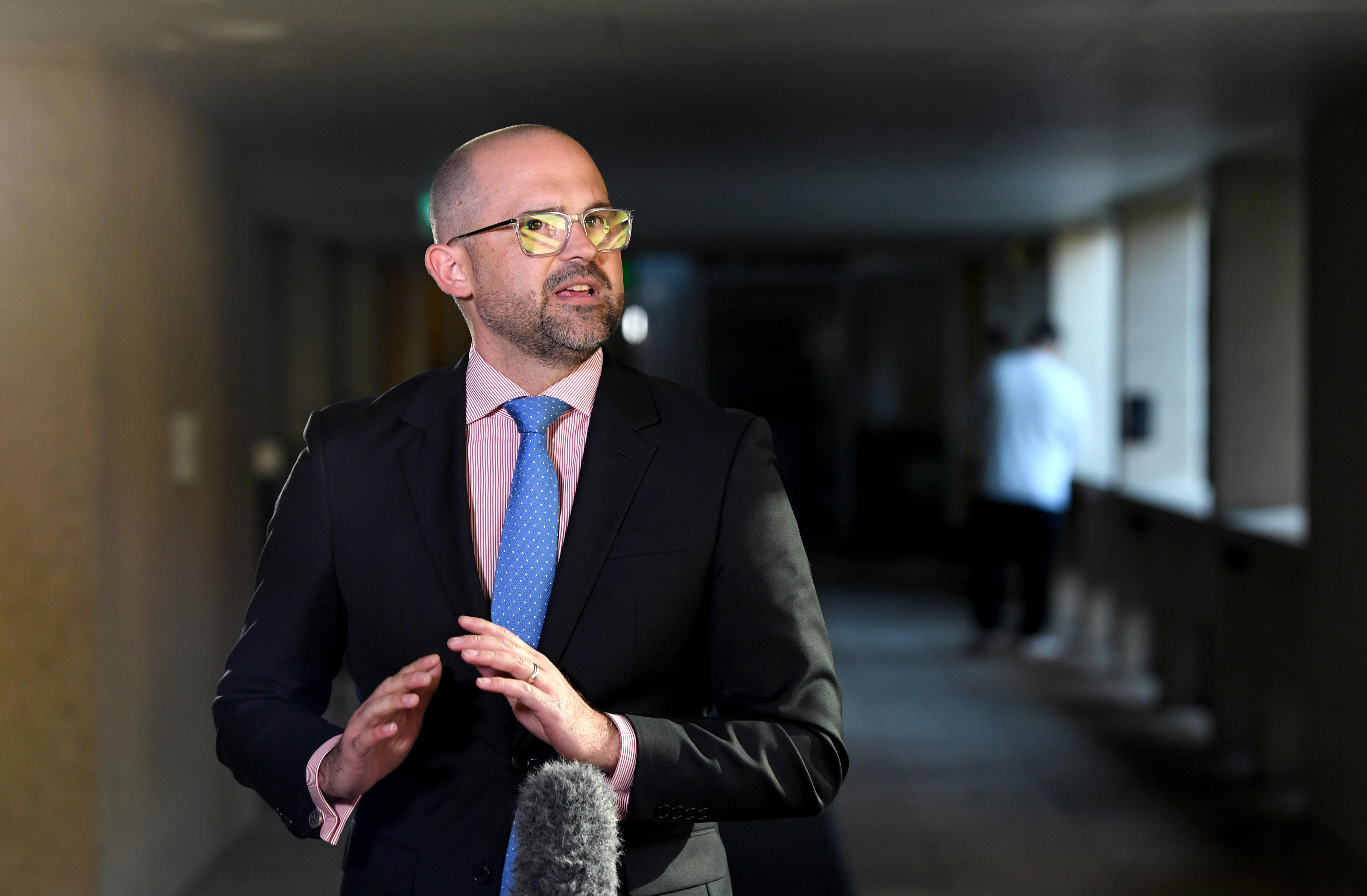 El tesorero de la oposición hablando ante un micrófono durante una rueda de prensa