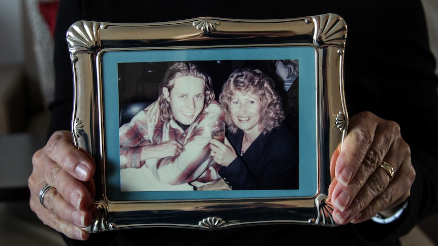 Sally Wilkinson holding a photo frame with a shot of her and her son Daniel.