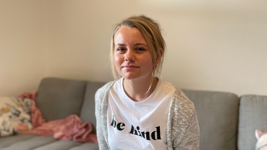 Girl smiles at camera while sitting on couch