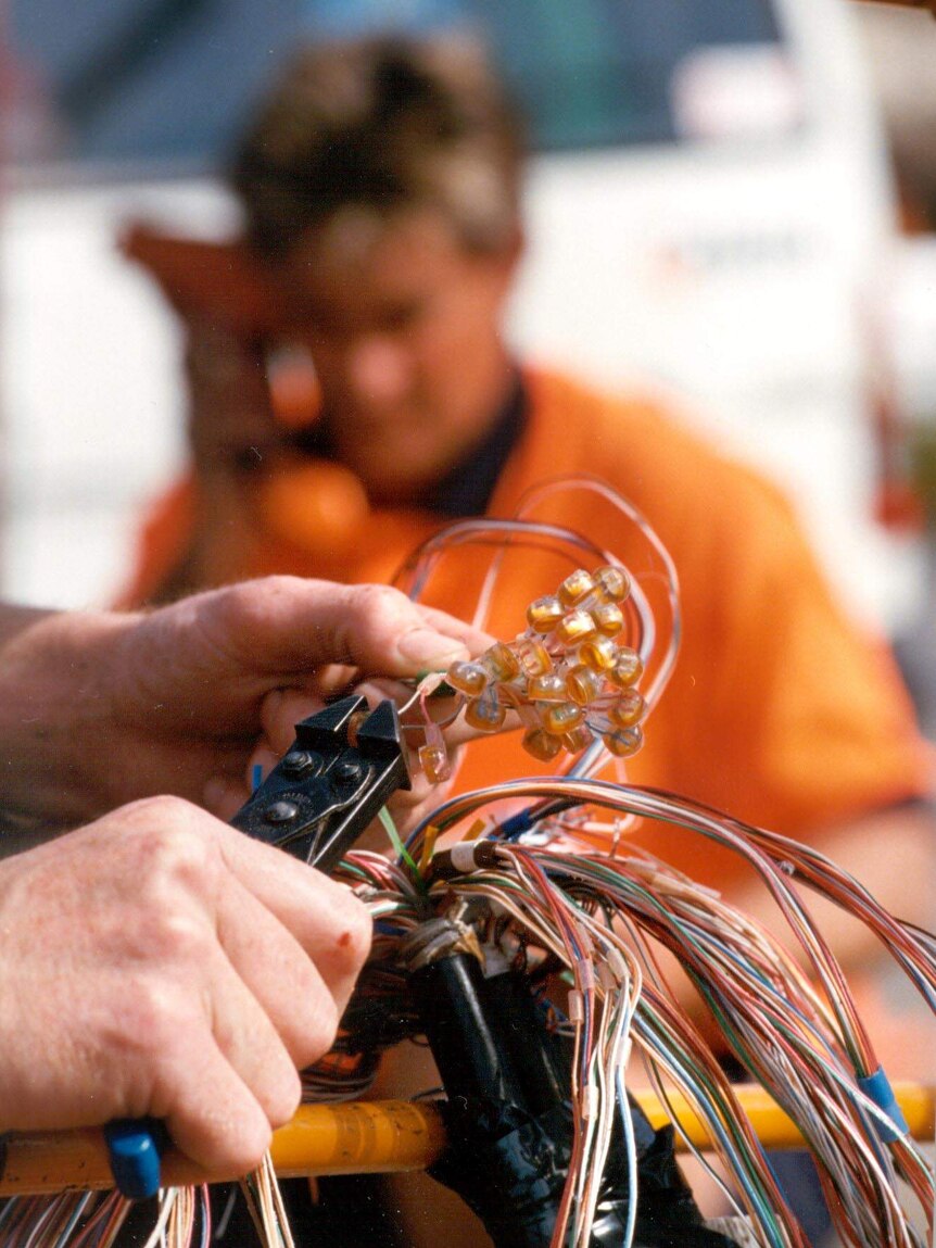 A Telstra technician connects customer lines.