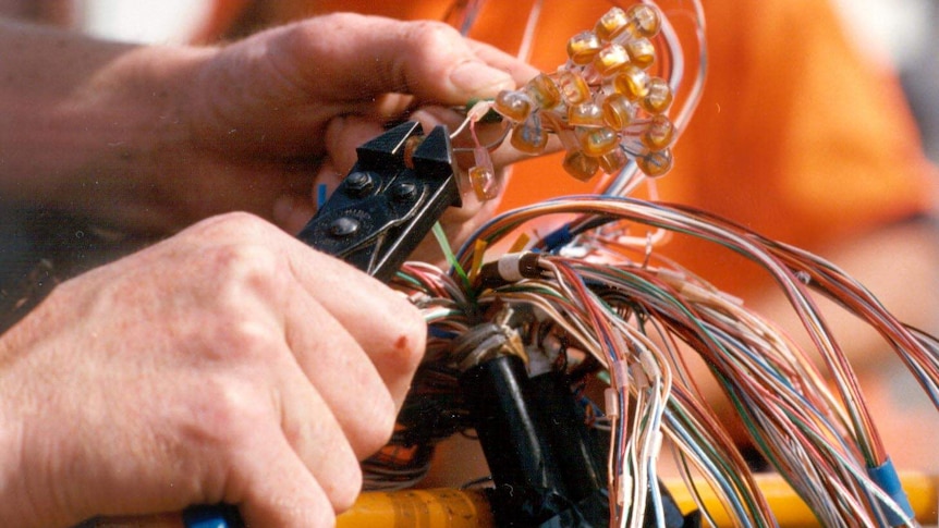 A Telstra technician connects customers lines.