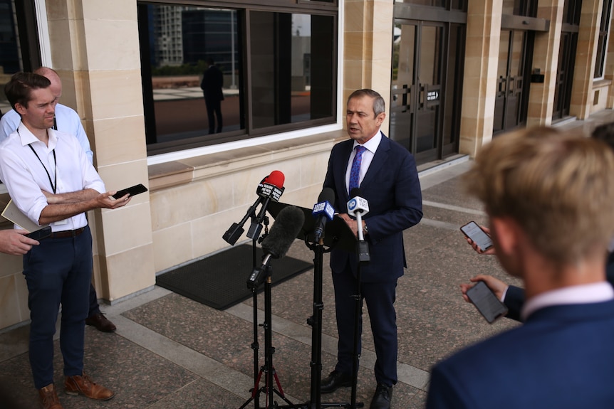 Media surround Roger Cook who delivers a press conference at WA parliament