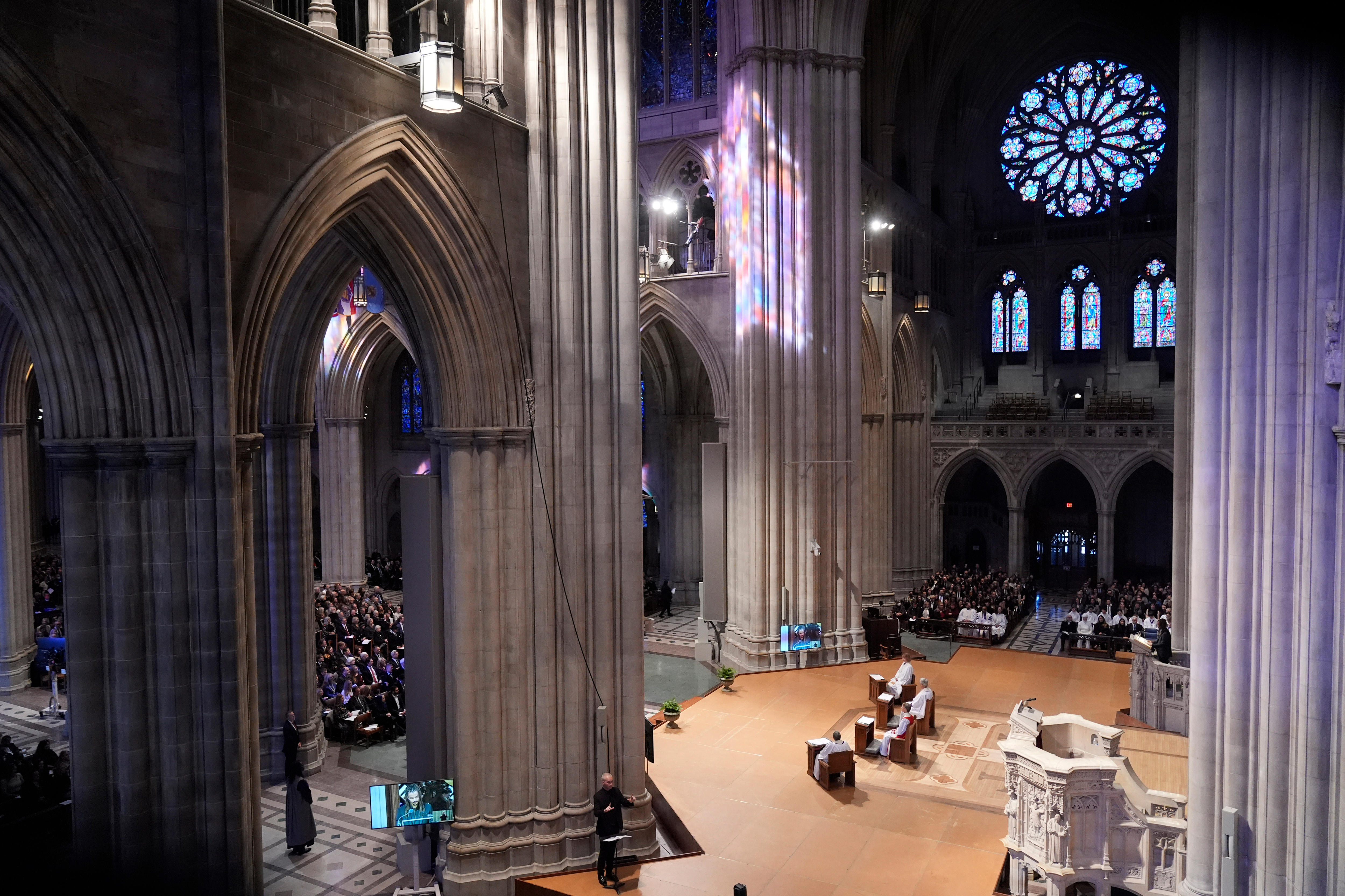 Stained glass, archways and imposing pillars inside a cathedral.
