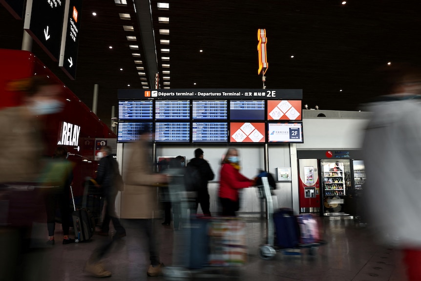 Passengers walk in the departures area of Paris Charles de Gaulle airport.