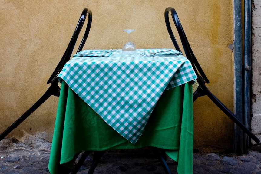 A table with a green table cloth and two chairs leaning on the table for a story about being single after divorce.